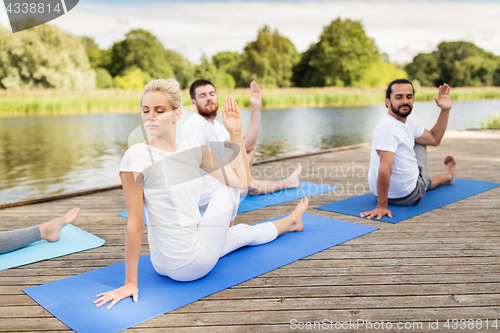 Image of people making yoga in half lord of the fishes pose