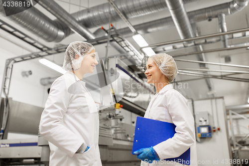 Image of happy women technologists at ice cream factory