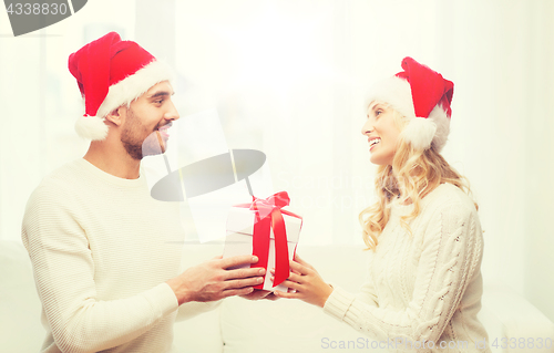 Image of happy couple at home with christmas gift box