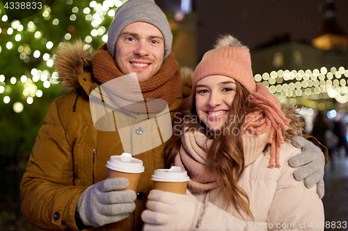 Image of happy young couple with coffee at christmas market