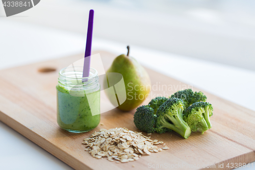 Image of jar with puree or baby food on wooden board