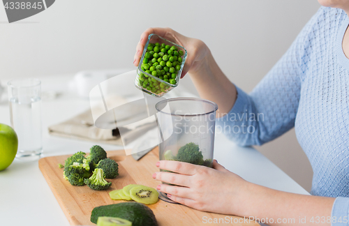 Image of woman hand adding pea to measuring cup