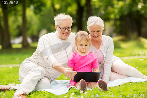 Image of grandparents and granddaughter with tablet pc