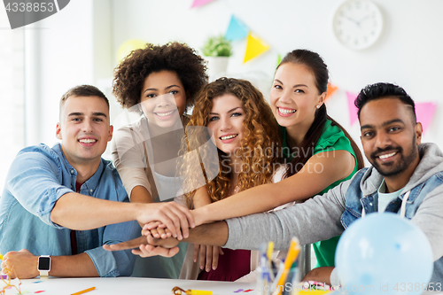 Image of happy team at office party holding hands together