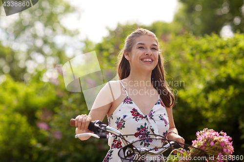 Image of happy woman riding fixie bicycle in summer park