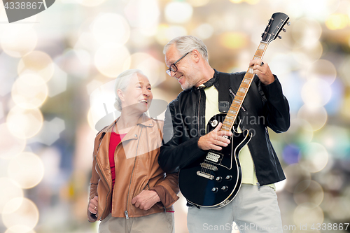 Image of happy senior couple with electric guitar