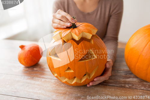 Image of close up of woman with halloween pumpkin at home