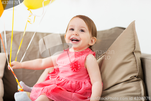 Image of happy baby girl on birthday party at home