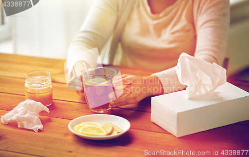 Image of close up of ill woman drinking tea with lemon