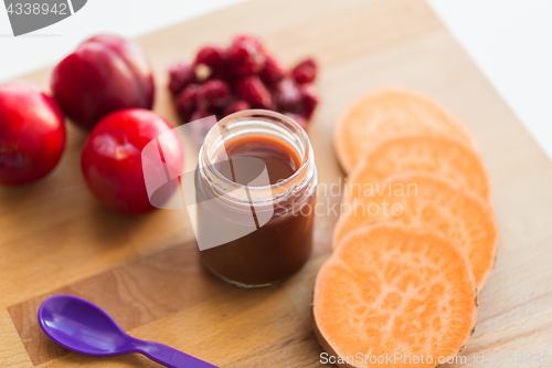 Image of fruit puree or baby food in jar and feeding spoon