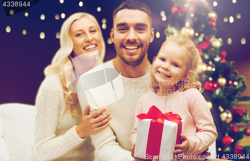 Image of happy family at home with christmas gift box