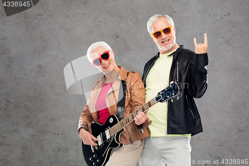 Image of senior couple with guitar showing rock hand sign