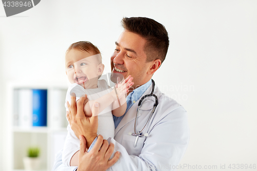 Image of happy doctor or pediatrician with baby at clinic