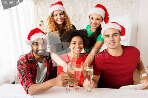 Image of happy team celebrating christmas at office party