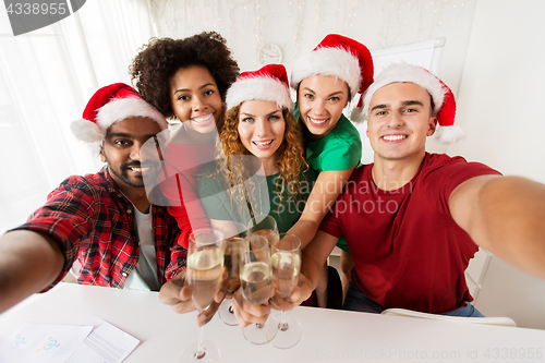 Image of happy team celebrating christmas at office party