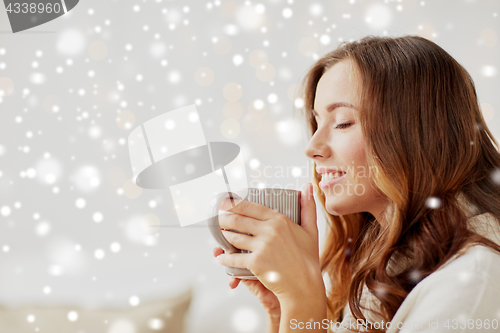 Image of happy woman with cup of tea or coffee at home