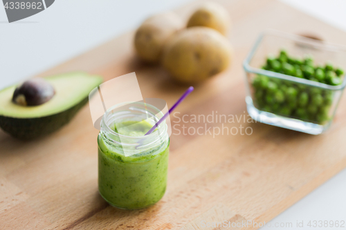 Image of jar with puree or baby food on wooden board