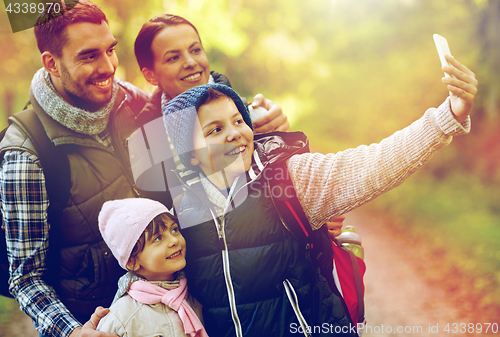 Image of family taking selfie with smartphone in woods