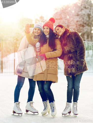 Image of happy young women with smartphone on skating rink