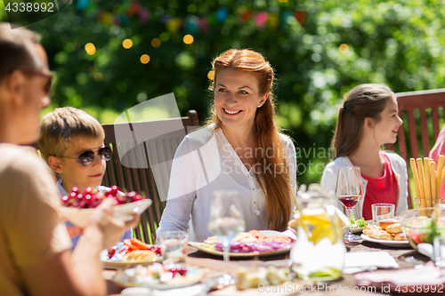 Image of happy family having dinner or summer garden party