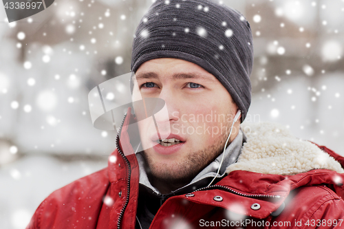 Image of man with earphones listening to music in winter