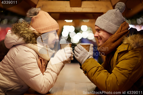 Image of happy young couple with coffee at christmas market