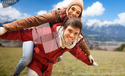 Image of happy young couple having fun over alps mountains