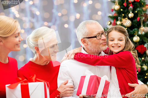 Image of happy family with christmas gifts over lights