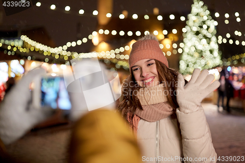 Image of happy woman posing for smartphone at christmas