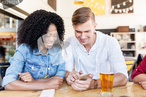 Image of happy man and woman with smartphone at bar