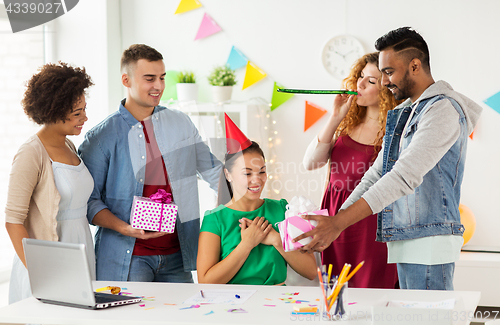 Image of team greeting colleague at office birthday party