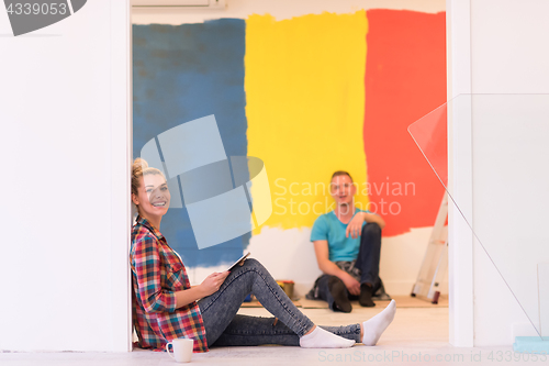 Image of Happy young couple relaxing after painting