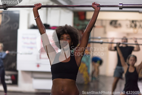 Image of black woman lifting empty bar