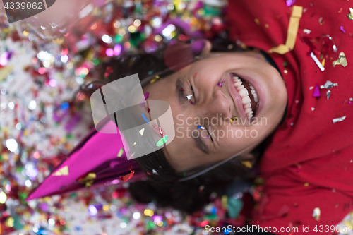 Image of kid blowing confetti while lying on the floor