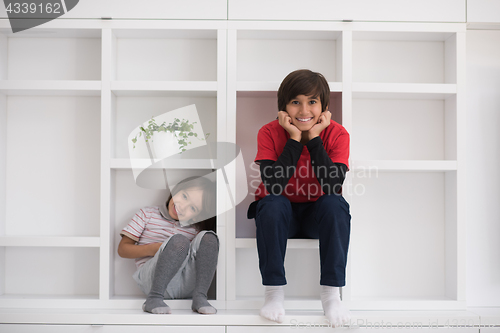 Image of young boys posing on a shelf