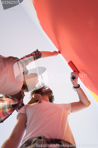 Image of couple painting interior wall