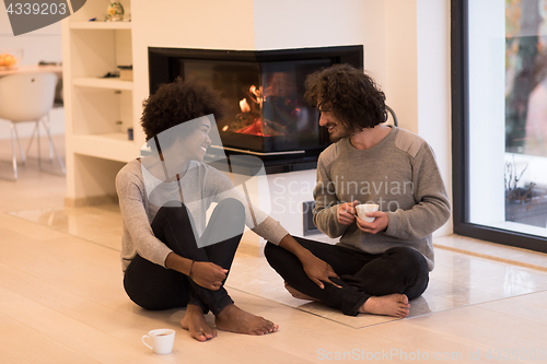 Image of multiethnic couple  in front of fireplace