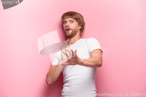 Image of Crazy desperate good-looking man being shocked looking at camera with wide opened mouth