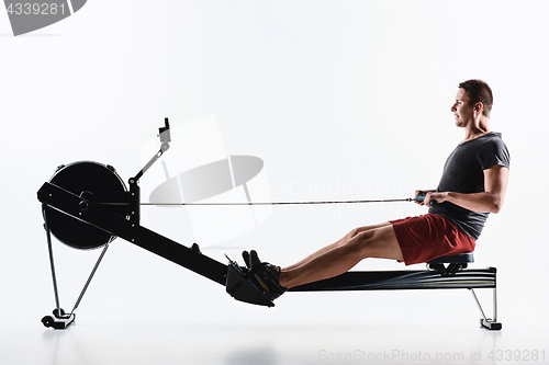 Image of Man Using A Press Machine In A Fitness Club.