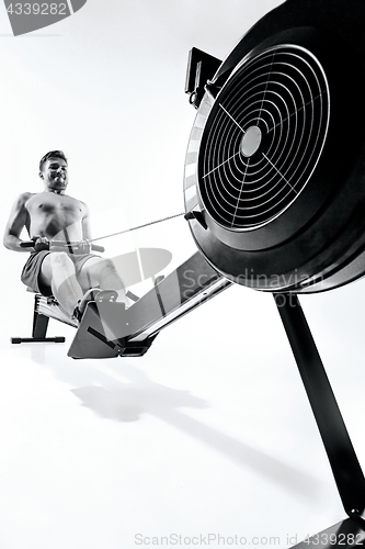 Image of Man Using A Press Machine In A Fitness Club.