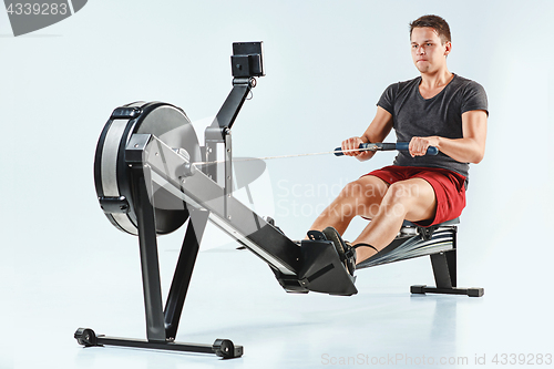 Image of Man Using A Press Machine In A Fitness Club.