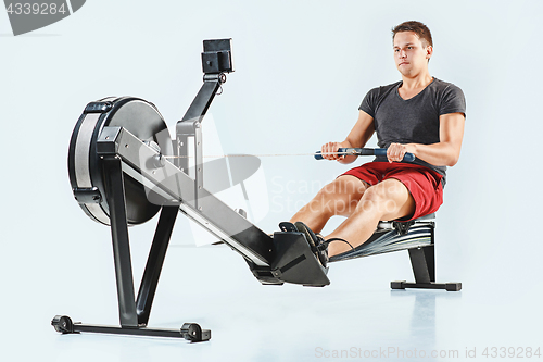 Image of Man Using A Press Machine In A Fitness Club.
