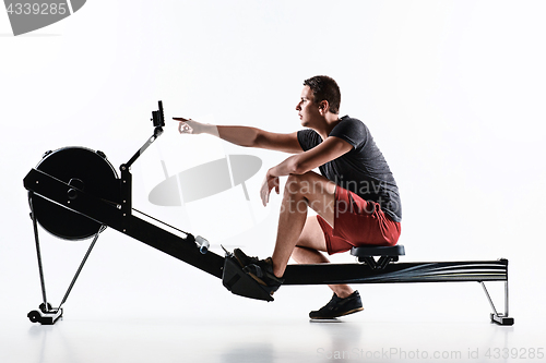 Image of Man Using A Press Machine In A Fitness Club.