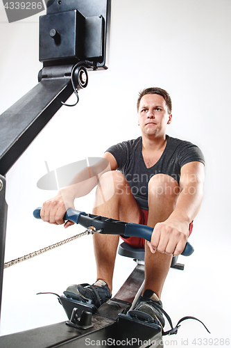 Image of Man Using A Press Machine In A Fitness Club.