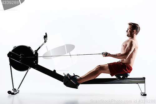 Image of Man Using A Press Machine In A Fitness Club.