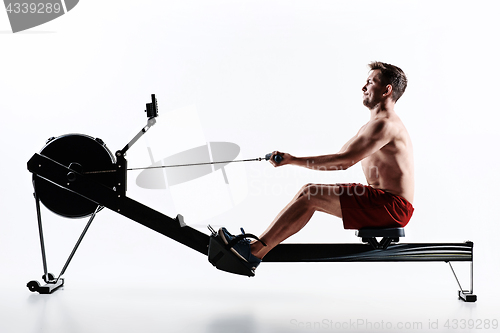 Image of Man Using A Press Machine In A Fitness Club.