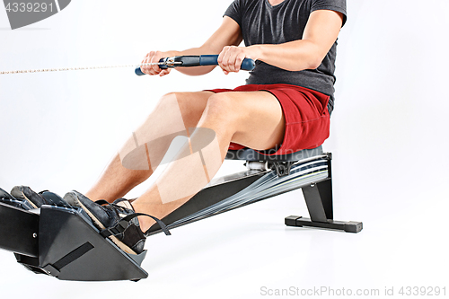 Image of Man Using A Press Machine In A Fitness Club.