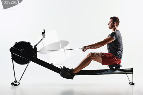 Image of Man Using A Press Machine In A Fitness Club.