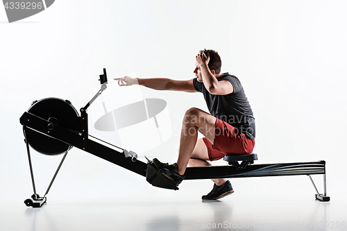 Image of Man Using A Press Machine In A Fitness Club.