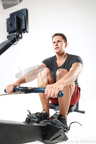 Image of Man Using A Press Machine In A Fitness Club.